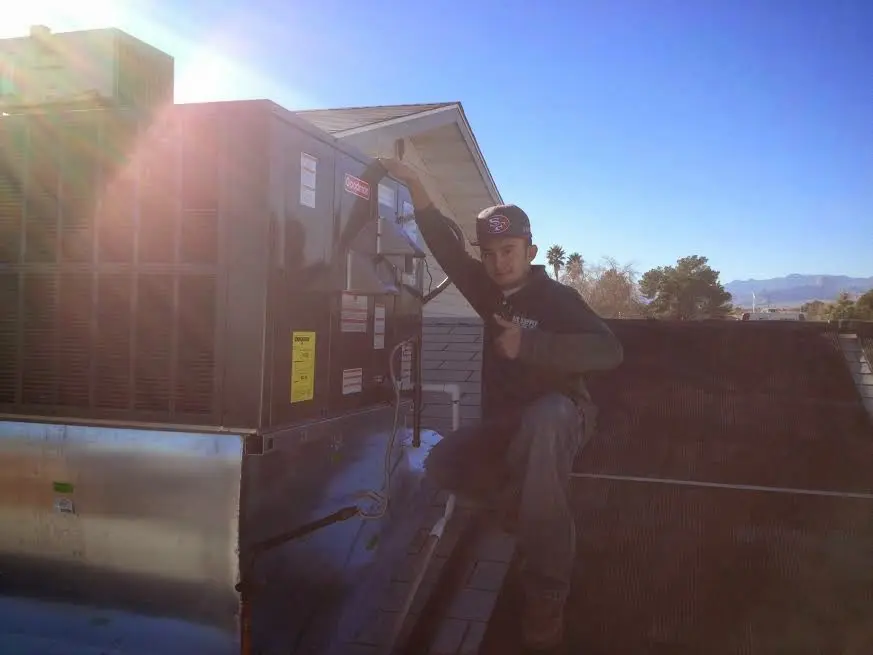 HVAC technician performing HVAC Inspection on a rooftop unit in Winfield